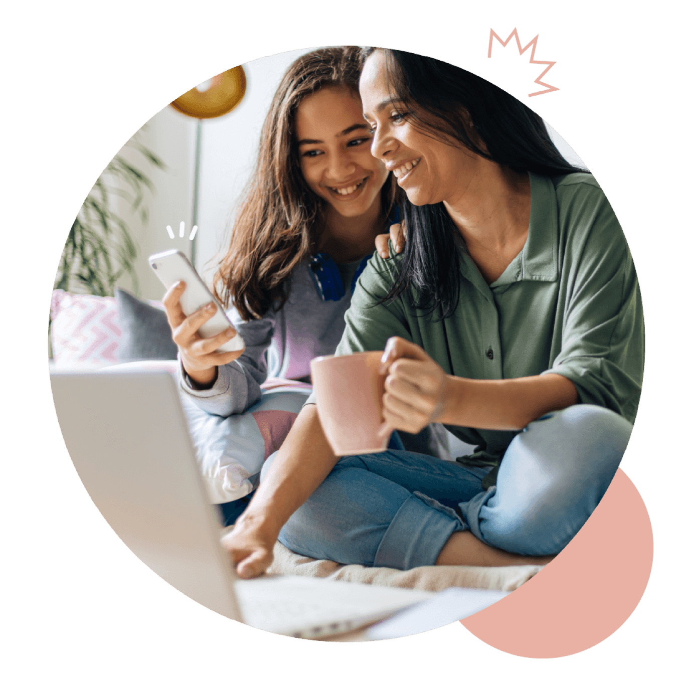 Une mère et sa fille sourient en regardant un smartphone ensemble sur un canapé